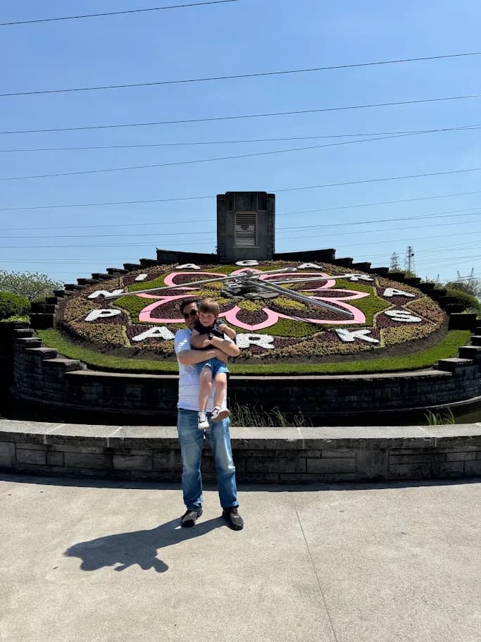 Adult and child posing in front of the Niagara Floral Clock