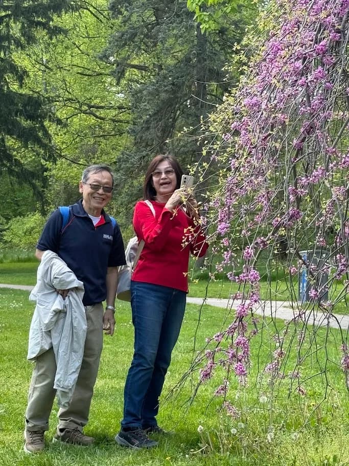 Two guests standing beside flowering trees during a Niagara stop