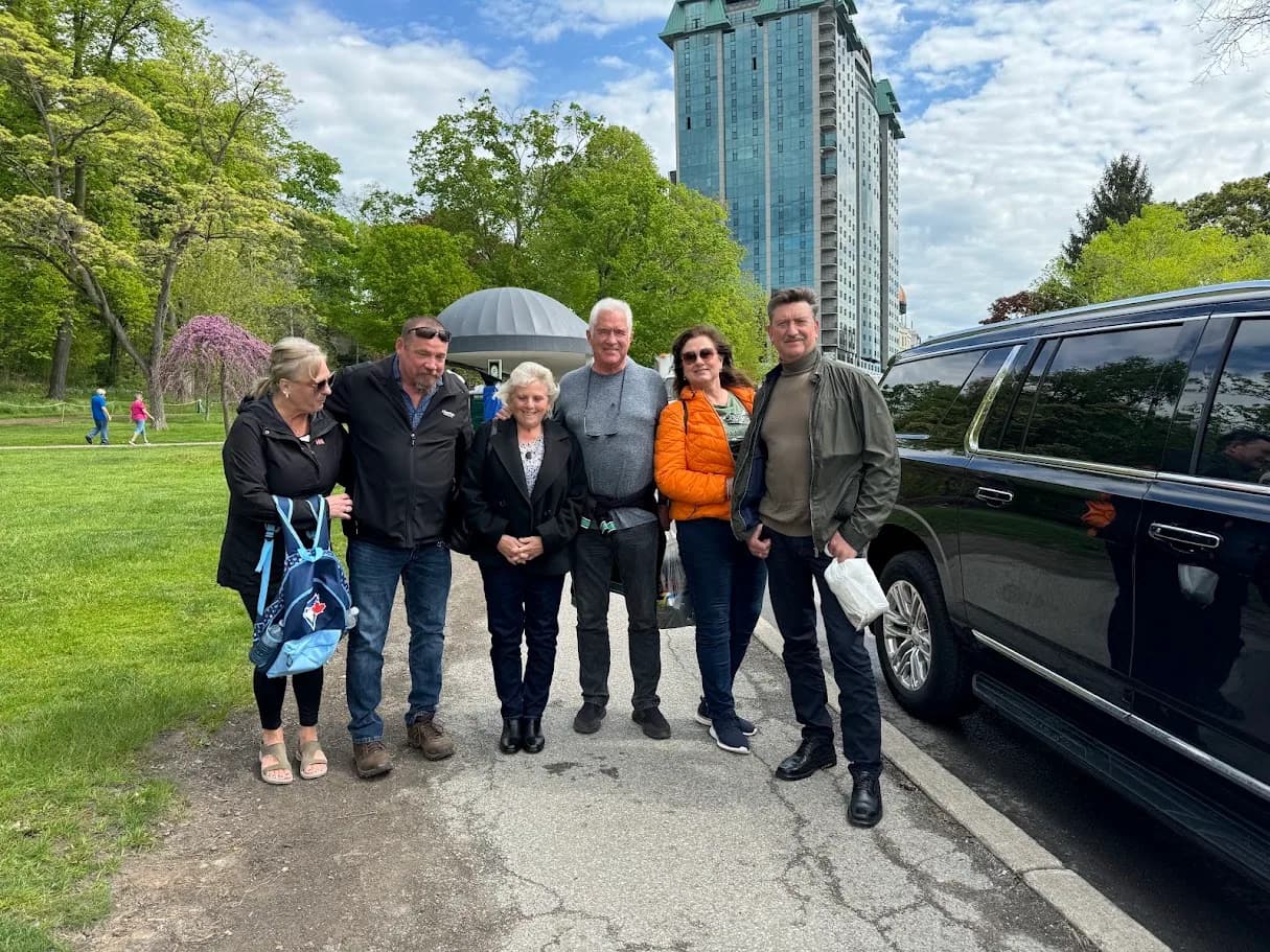 Private tour group standing beside a black SUV near the Niagara Parkway