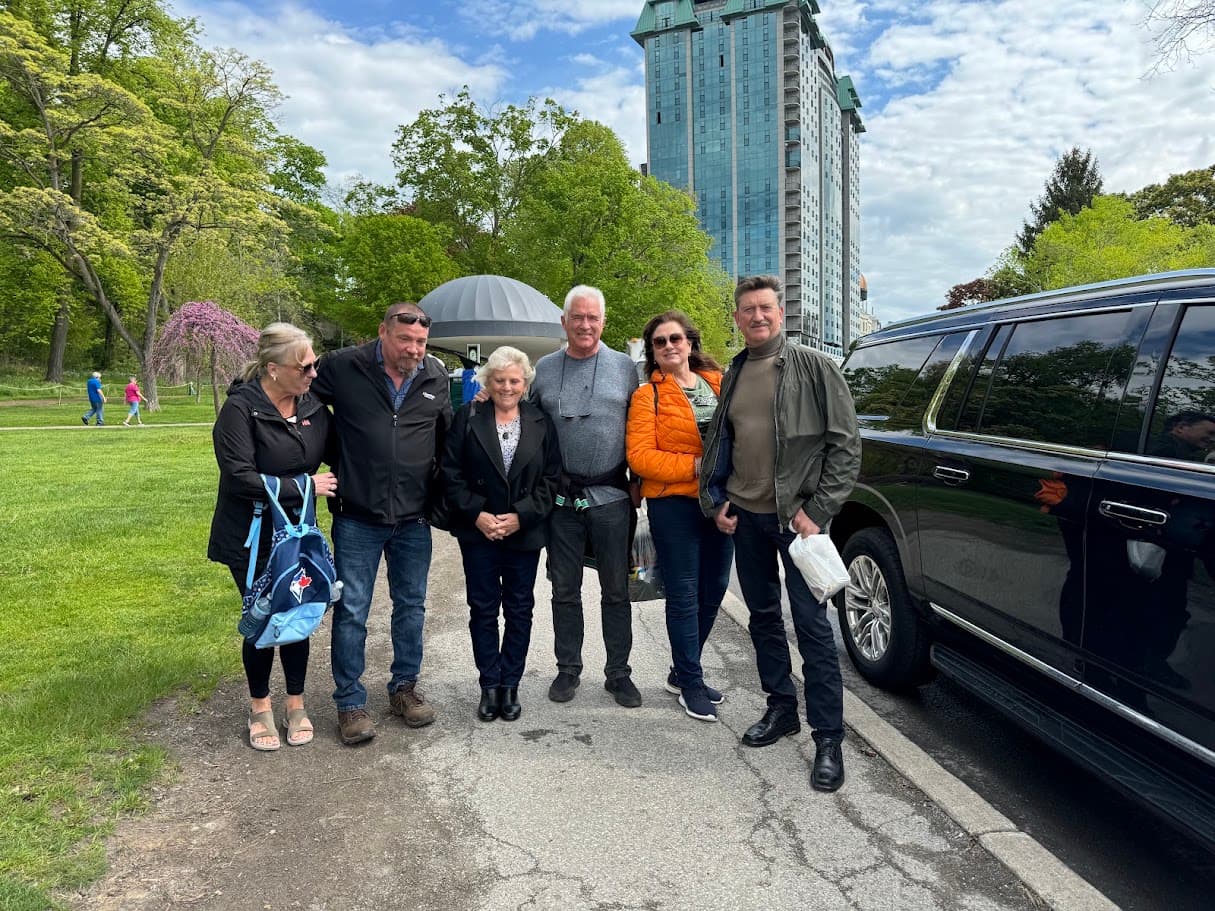 Tour Niagara guests standing beside a black SUV during a GTA-area pickup