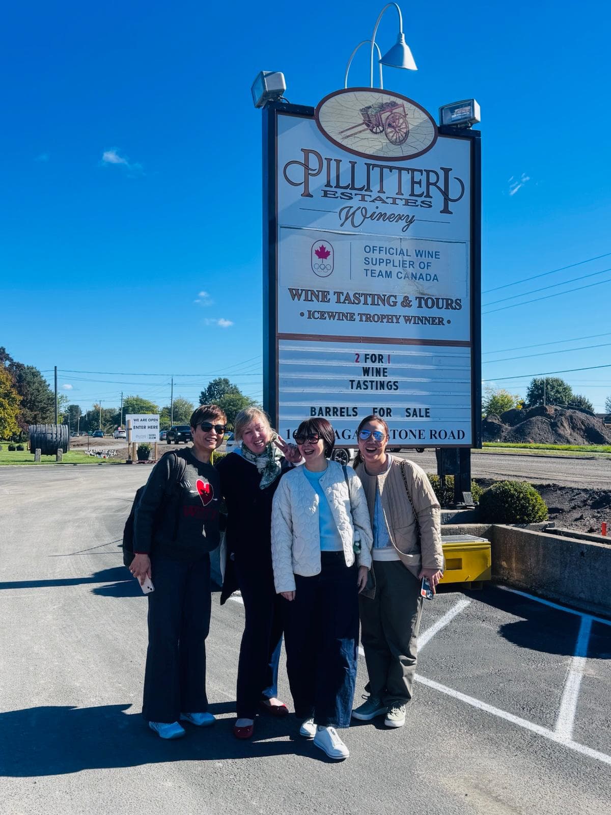 Private wine tour group posing beside the Pillitteri Estates Winery sign